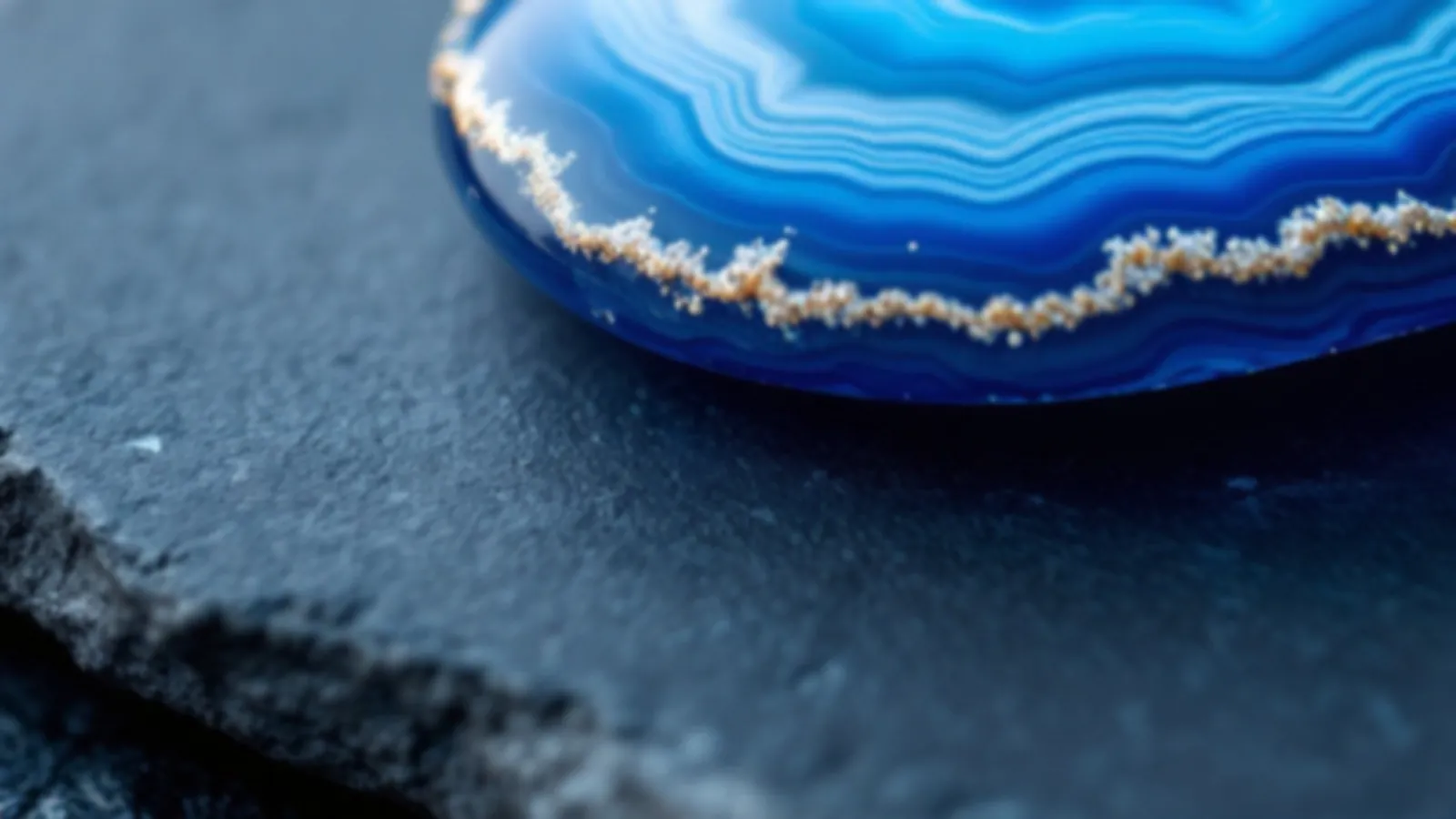 Macro view of a blue and white banded agate stone on smooth slate in soft light, the FinanceAgate view of online installment loans, $100 – $5,000